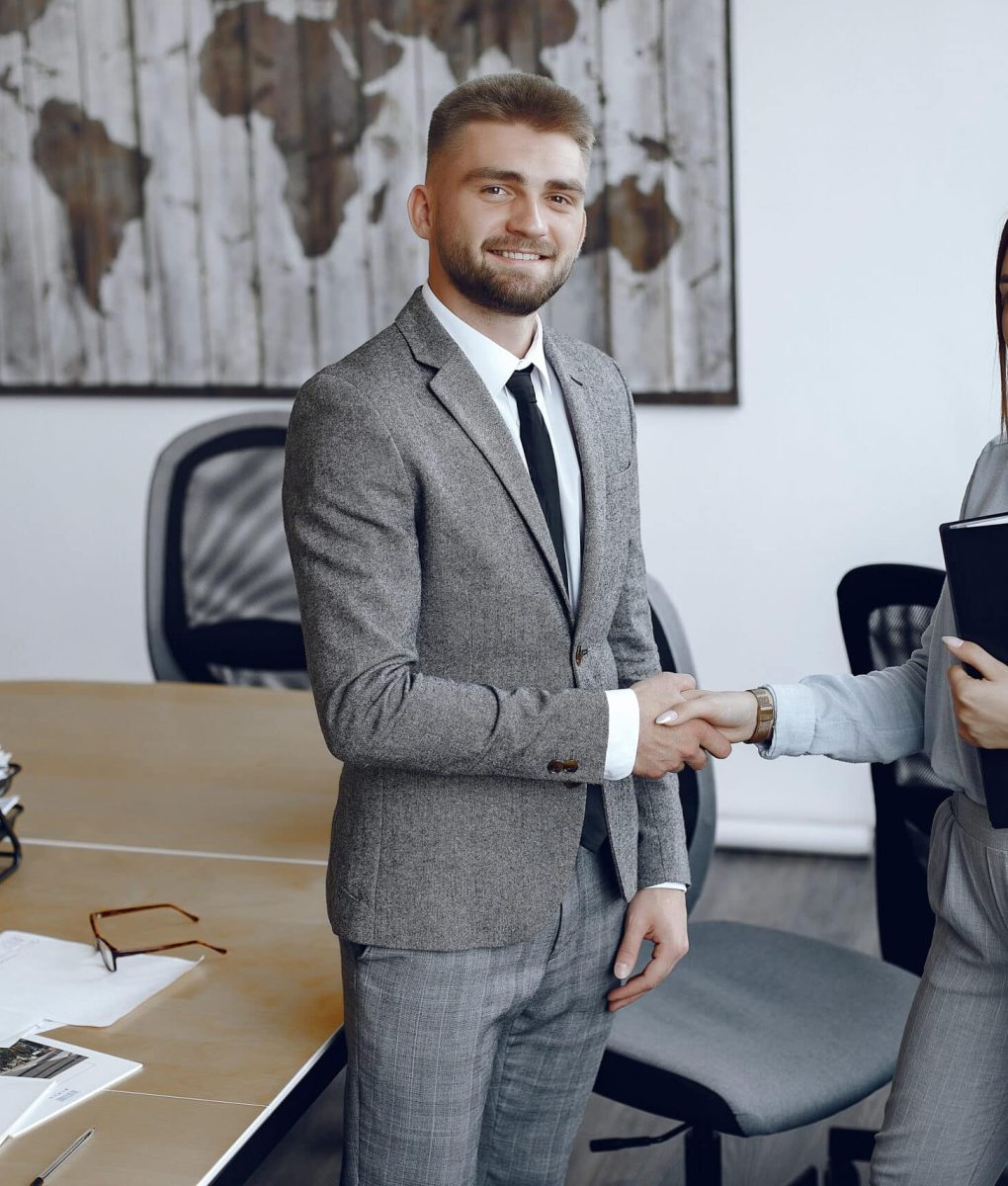 Woman holding a folder in her hands.Businessman in his office. Colleagues shake hands