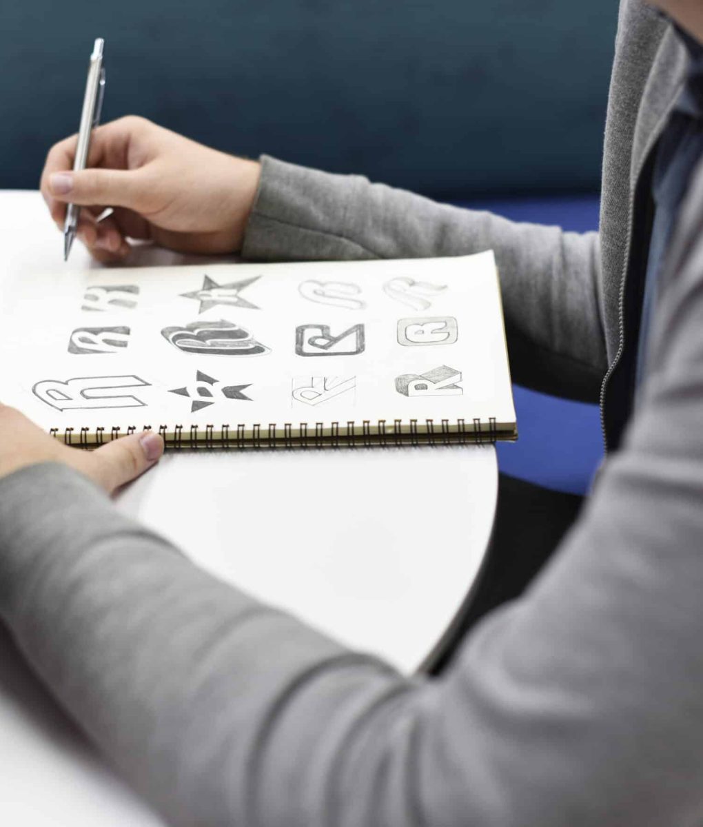 Hand Holding Notebook With Drew Brand Logo Creative Design Ideas